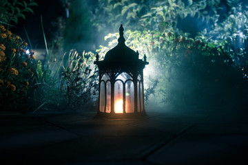 Retro style lantern at night. Beautiful colorful illuminated lamp at the balcony in the garden....