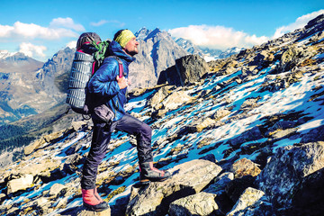 Hiker with backpacks reaches the summit of mountain peak. Success, freedom and happiness, achievement in mountains. Active sport concept.