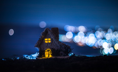 Little decorative house, beautiful festive still life, cute small house at night, Night city real bokeh background, happy winter holidays