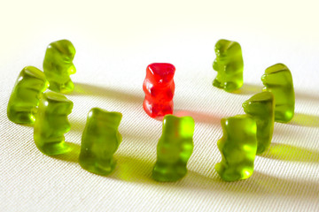 sweet candy gummy teddy bears representing group of students or work colleagues bullying and...