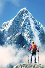 Hiker with backpacks reaches the summit of mountain peak. Success, freedom and happiness, achievement in mountains. Active sport concept.