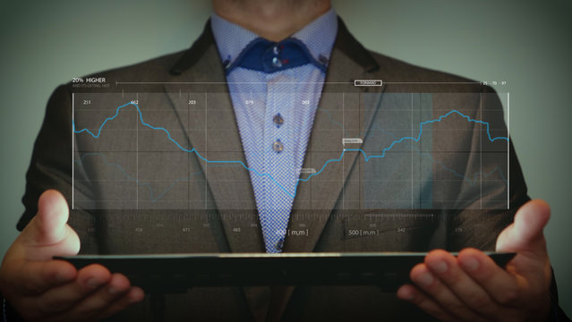 Futuristic portrait man holds in his hands a digital tablet which is a hologram of infographics. Concept from: Holograms, Future, Graphic technology, Infographic, Numbers, Values.