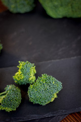 Nice broccoli crowns on a black slate board.
