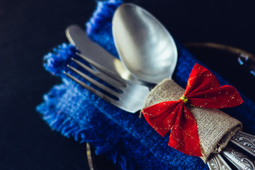 Silver cutlery with the red christmas bow.