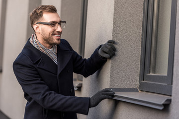 happy smiling adult man looking into window