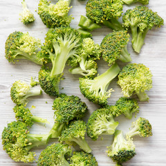 Freshly cut raw broccoli on white wooden table, top view. Flat lay, from above.