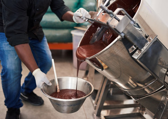 Worker melting chocolate while at work in a confectionary factory