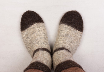 male legs in gray knitted socks made of dog hair close-up, top view