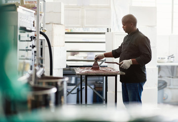 Fototapeta premium Artisanal chocolate maker working at a factory table