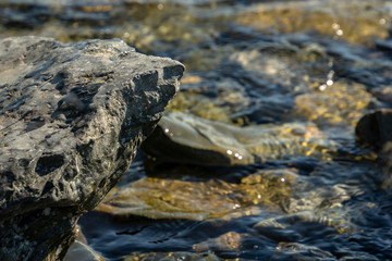 Sea stones and rocks of different sizes and texsture of black, gray and brown under the water on the Black Sea coast as nature bacground. Excellent concept for any design