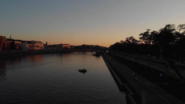 Wisła w Krakowie o zachodzie słońca, biegacz biegnie bulwarami