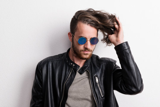 Portrait of a young man with sunglasses in a studio.
