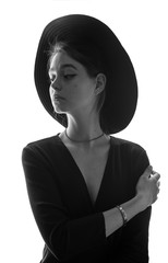 Beautiful, young girl in a stylish felt hat with wide brim sad and nostalgic