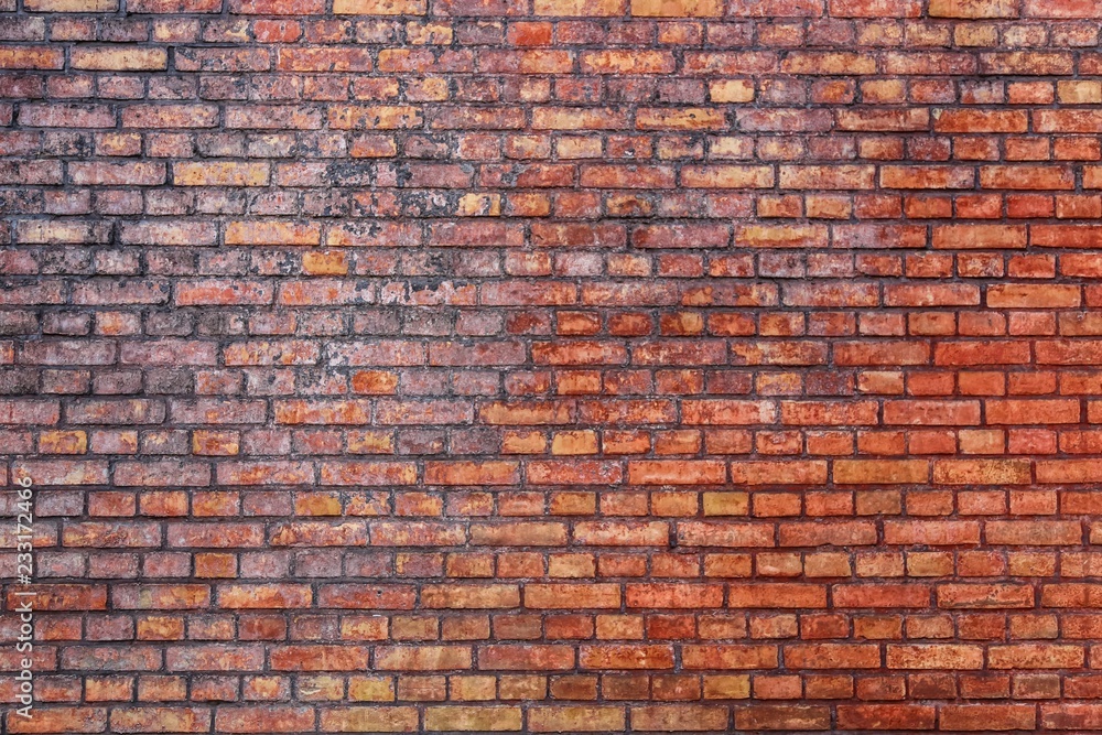 Poster old and weathered grungy red brick wall marked by the long exposure to the elements as surface textu