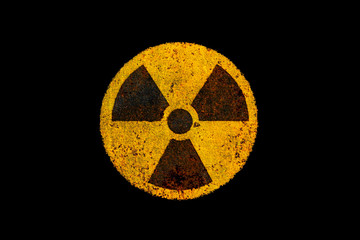 Round yellow and black radioactive (ionizing radiation) nuclear danger symbol on rusty metal grungy...