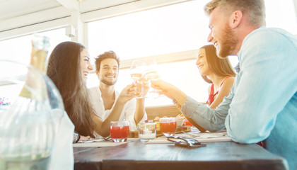 Group of best friends celebrating toasting with wine at the restaurant