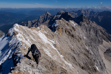 Mann klettert hoch oben am Grat, Jubiläumsgrat Alpen