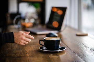 Hand Reaching For Coffee Latte