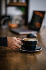 Hand Reaching For Coffee Latte