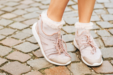 Woman wearing new comfy trainers and soft pink ruffle socks, close up image