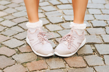 Woman wearing new comfy trainers and soft pink ruffle socks, close up image