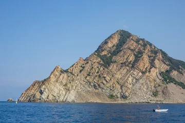 Fotobehang Fisherman in a small boat at the entrance to Monterosso al Mare harbour, Cinque Terre, Italy © Michael Evans