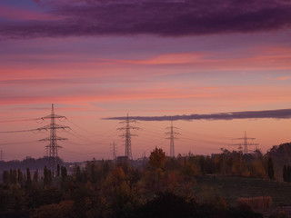 Fototapeta premium Stromtrasse im Ruhrgebiet bei rötlich violettem Morgenlicht