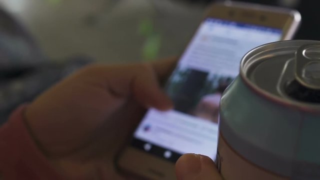 Woman scrolling social network photos, hand holding can of beer, free time
