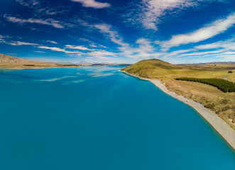 Aerial drone shots of Lake Tekapo with reflection of sky and mountains, New Zealand