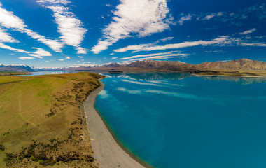 Aerial drone shots of Lake Tekapo with reflection of sky and mountains, New Zealand