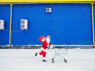 Santa Claus with cart on store background