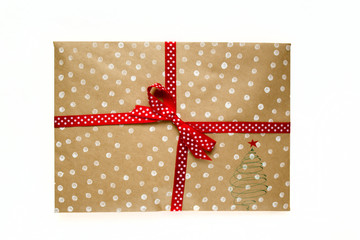 Kraft envelope in white peas with red ribbon and bow on white background. new year gift.