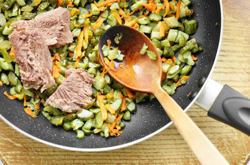 Frying pan with beef carrot and greens
