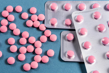 pink pills in a blister on a blue background