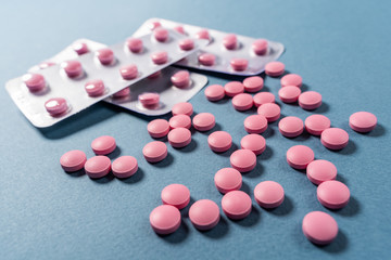 Colored pills, tablets on a blue background.
