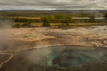 Icelandic landscape.Hot geyser spouting out of the ground 
