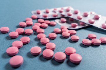 Obraz na płótnie Canvas Colored pills, tablets on a blue background.