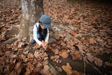 落ち葉で遊ぶ少女