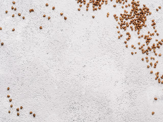Buckwheat with copy space. Brown raw buckwheat grain on gray concrete textured background. Top view or flat lay. Copy space. Healthy food and diet concept. Buckwheat background.
