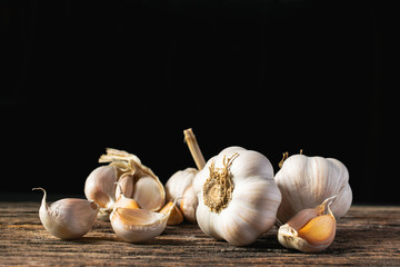 Closeup garlic on wooden texture on for cooking on dark background