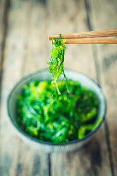 Seaweed hanging from chopsticks