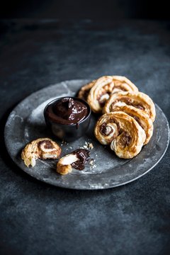 Cinnamon palmiers with chocolate sauce served on plate