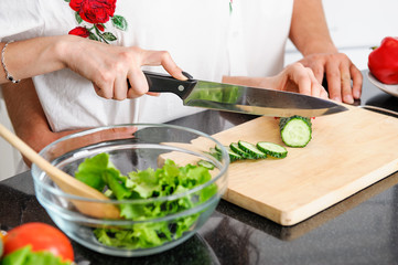young man and woman hands cooking healthy vegetarian food from fresh vegetables