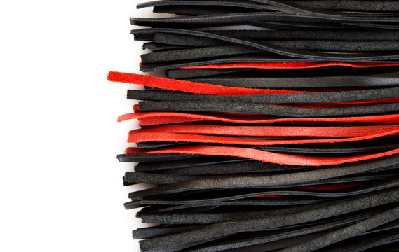 Red-black floger with leather tails on white background.concept of pleasure from pain