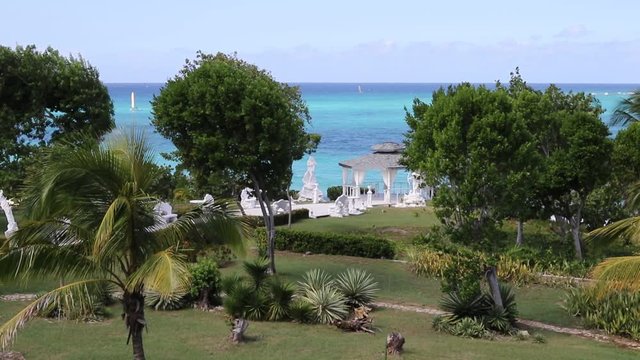 Beautiful Coconut palms and path to the Blue Atlantic Ocean beach in Holguin district of Cuba - October 31 2108.