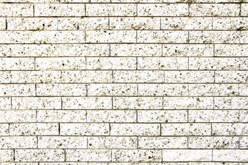 Simple grungy white brick stone wall as seamless pattern texture background.