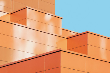 Modern building facade detail, abstract architectural metal shape against blue sky 