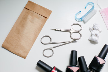 Scissors and a set of nail polish lying on a white table