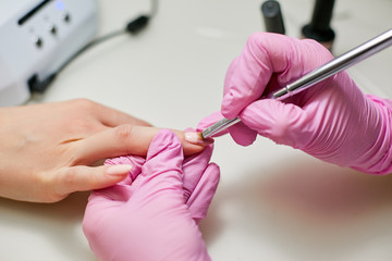 Master of manicure brush paints nail polish in pink