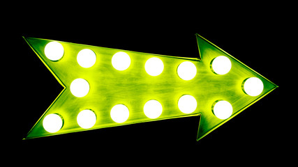 Green vintage bright and colorful illuminated metallic display arrow sign with glowing light bulbs isolated on a wide seamless black dark background.